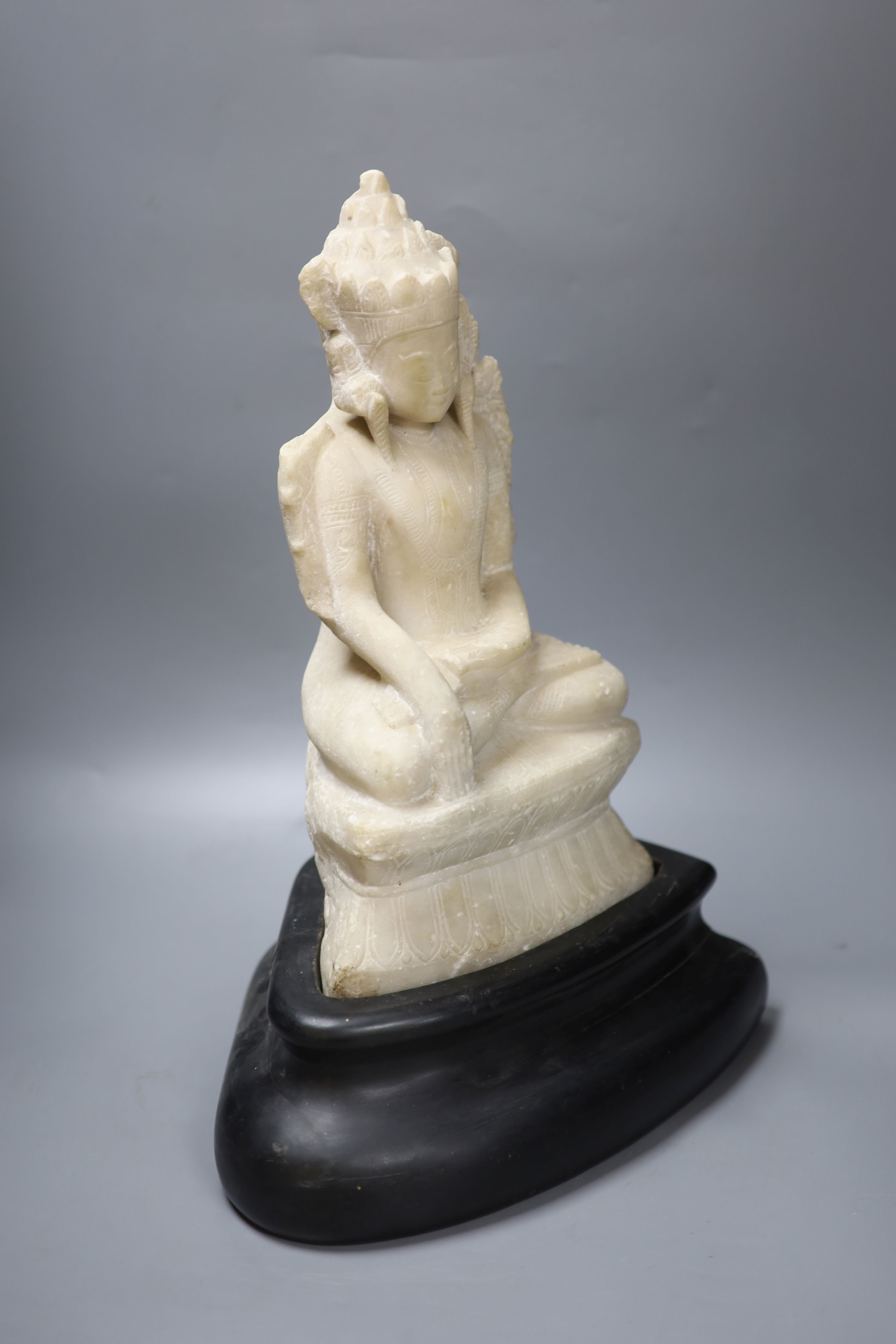 A 19th century Burmese marble crowned Jambhupati Buddha, on stand, overall height 47cm